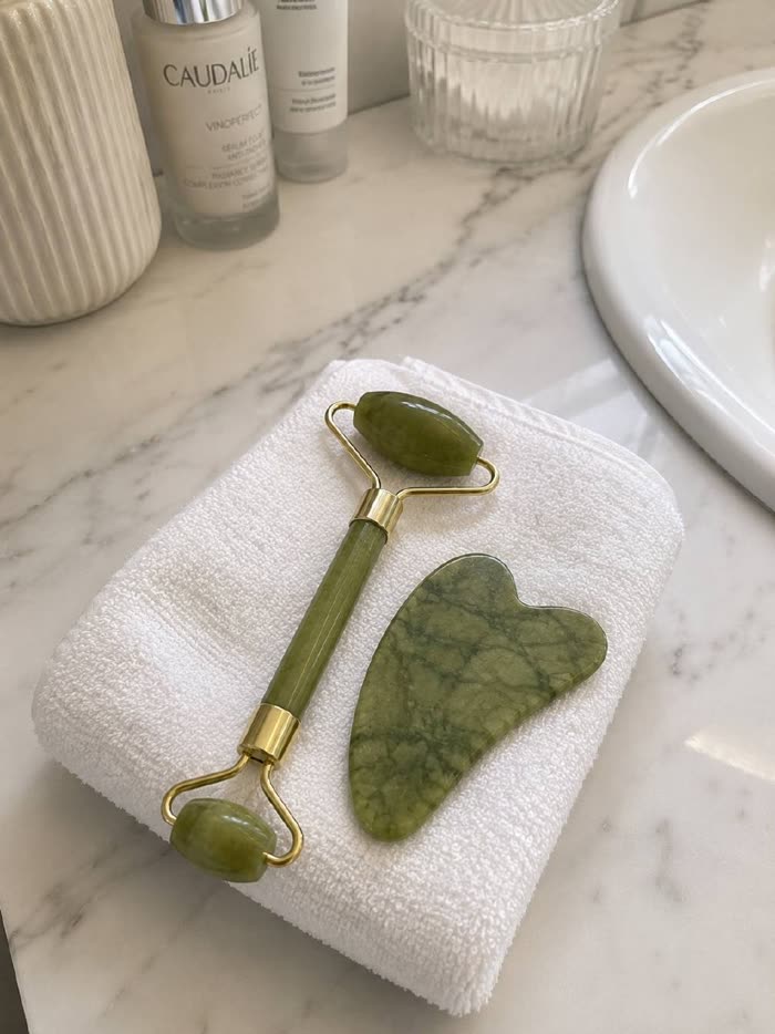 Set de jade sobre una toalla blanca en el baño de una clienta